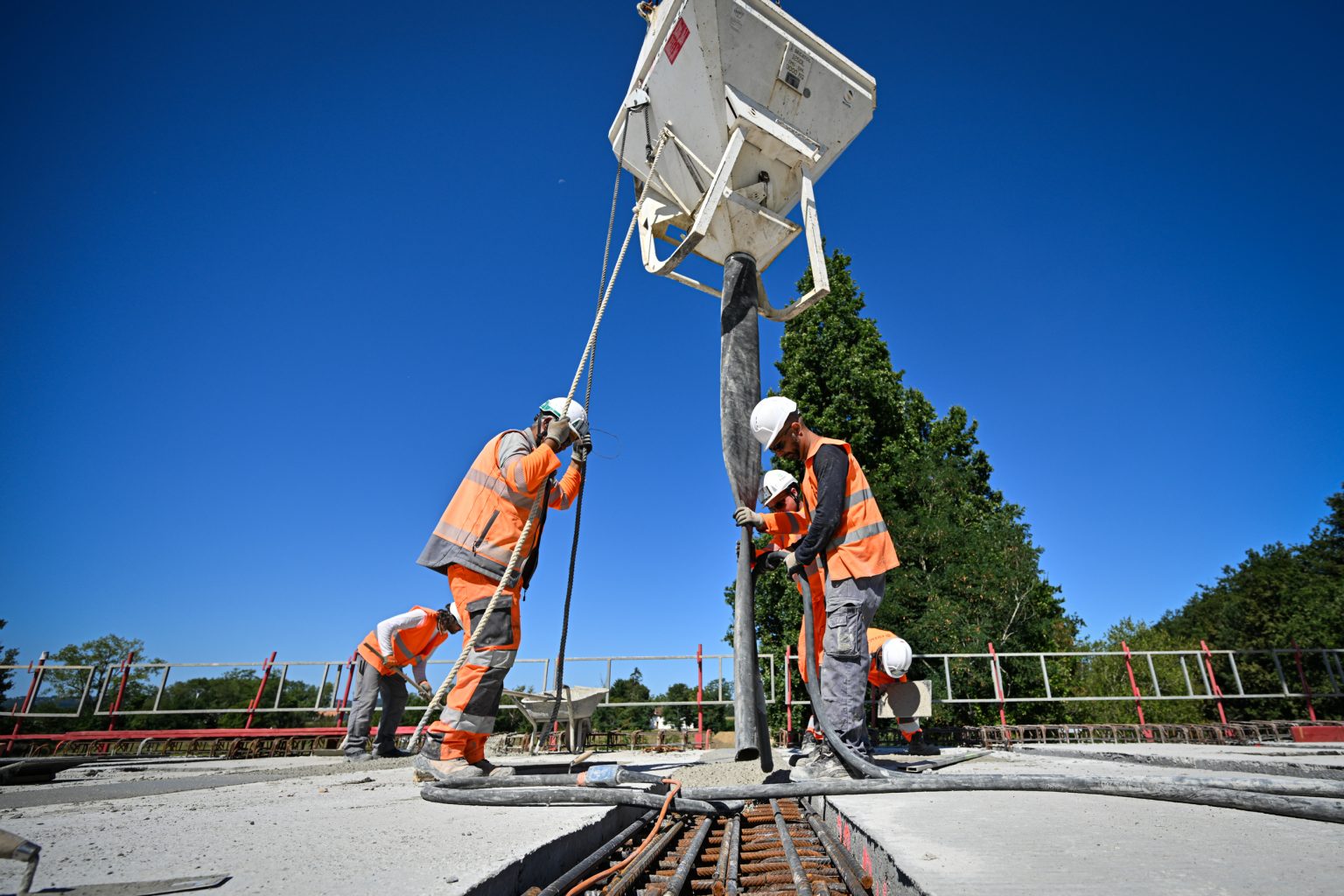Équipe de chantier au sol sous une charpente métallique